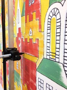 Botsy draws the outline over the color painted layer.